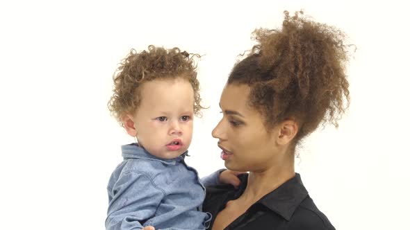 Afro American Mother Tells Her Little Baby Something Interesting. White Background alt