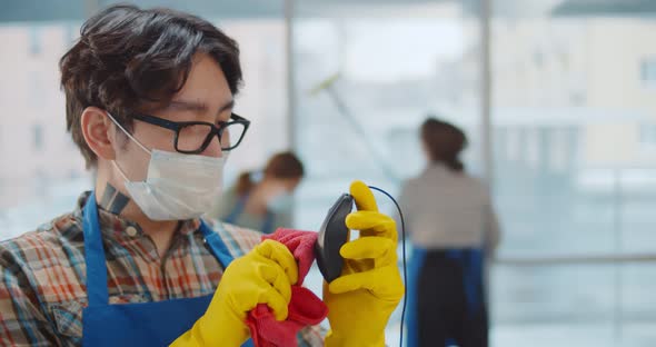 Close Up of Asian Janitor in Safety Mask Disinfecting Mouse with Cloth alt