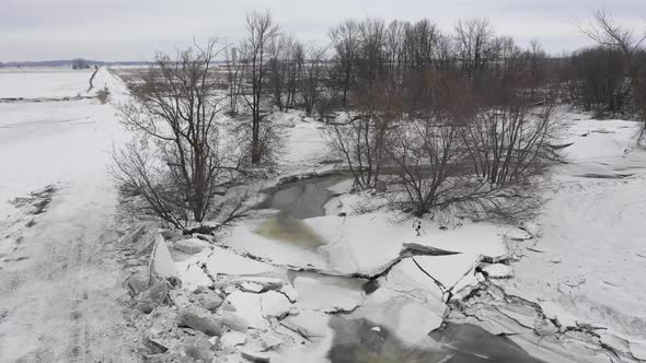 big ice build up beside the road from flooded frozen creek alt