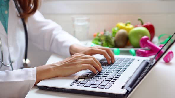 Nutritionist giving working on laptop and consultation to patient