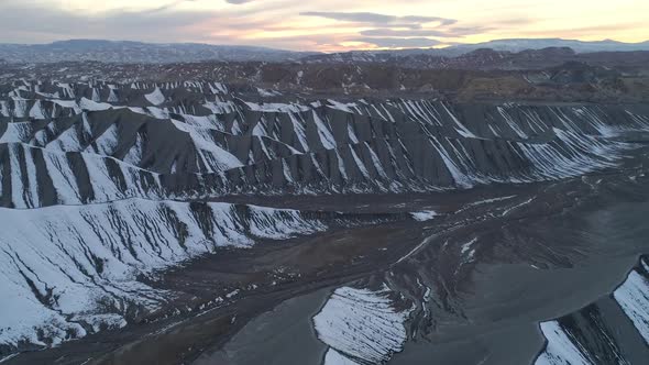 Flying over desert dunes at sunset viewing stripes from snow alt