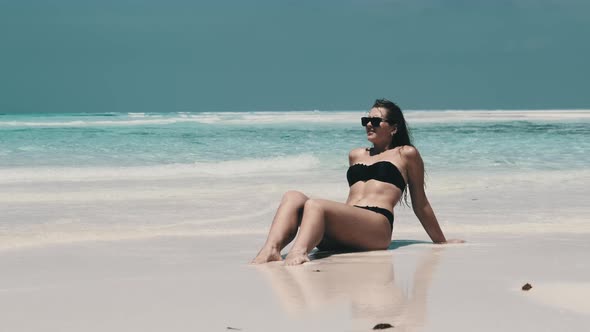 Young Woman in Bikini Tans on an Empty Paradise Beach on Island in Ocean Mnemba alt