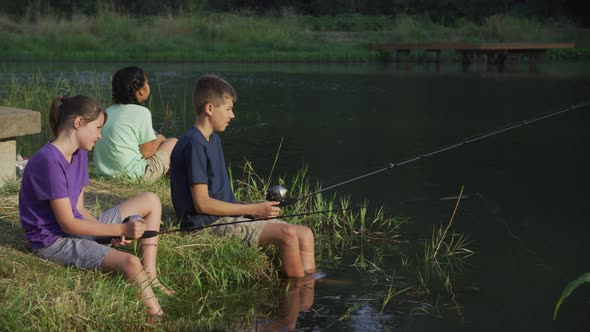 Kids at summer camp fishing in pond