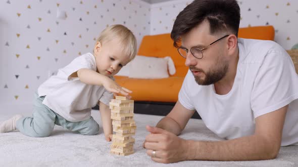 Father and Cute Toddler Son Playing Together with Wooden Bricks, Indoor