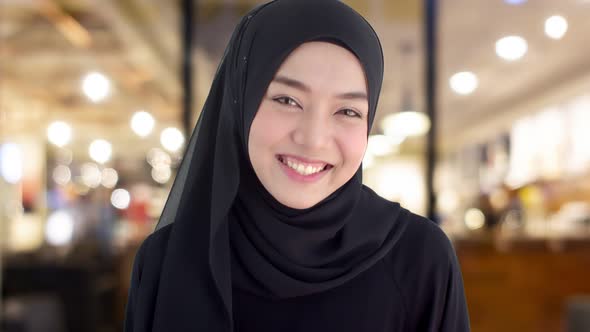 Portrait beautiful Muslim woman wearing traditional clothing laughing with shyness alt