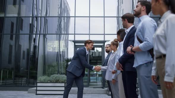 Thankful Leader Shaking Hands at Office Building alt