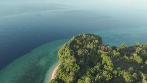 Aerial: flying over tropical Ai island white sand beach Banda Islands Maluku Ind alt