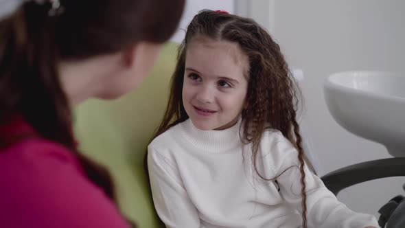 Happy Female Dentist Having Fun Talk with Child Before Treatment in Dental Chair alt