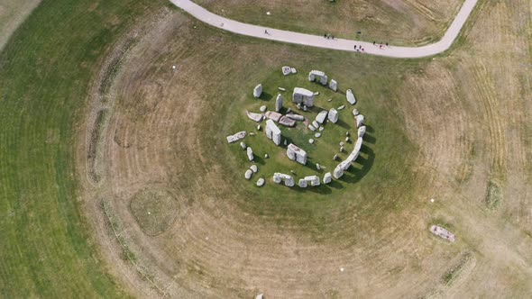 dolly back pan up top down drone shot of Stonehenge UK alt