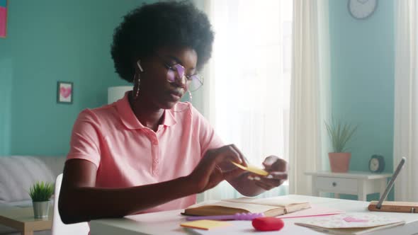 Young African Woman Is Makes Notes While Reading