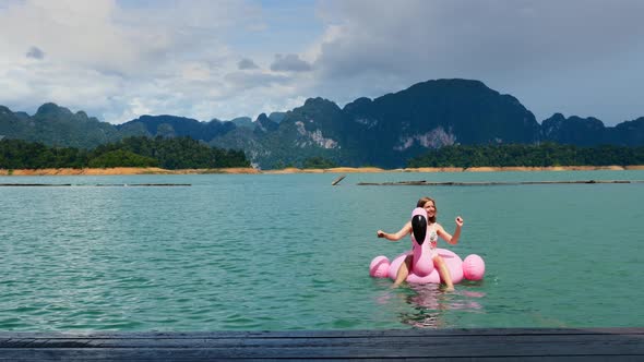 Smiling Woman Fun on on Pink Inflatable Flamingo Relax Sunbathing and Enjoying alt