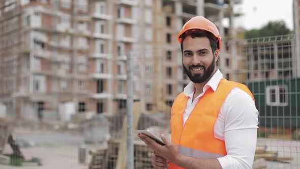Portrait of Construction Worker on Building Site with Tablet Looking at the Camera. Professions alt
