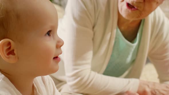 Laughing Baby Boy Playing with Senior Grandmother 