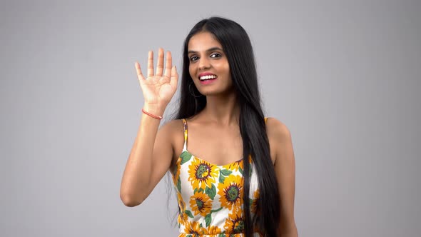 A beautiful and attractive Indian girl saying Hi to the camera with a huge smile alt