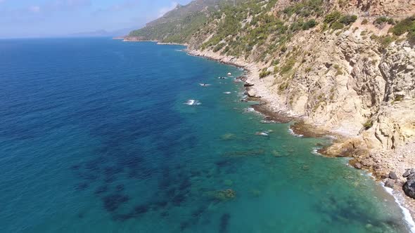 Aerial Clear Reef and Rocky Untouched Coastline of Bright Turquoise Sea alt