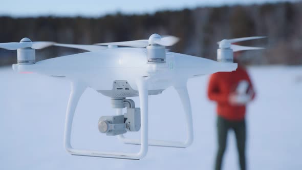 White Quadrocopter with Close Shutter of Camera Hovered in the Air