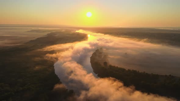 Aerial drone view of nature of Moldova at sunset. River and lush fog above it, greenery alt