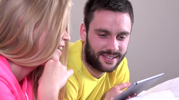 Young Happy Couple Watching Something on the Tablet alt