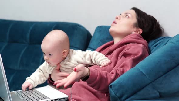 Freelancer Mother Sitting on Couch at Home Office During Lockdown