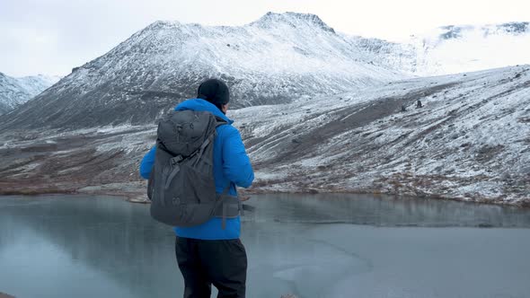 Tourist Rises To a High Point. In Front of Him Is a Beautiful Landscape, Mountain Peaks and a Clear alt