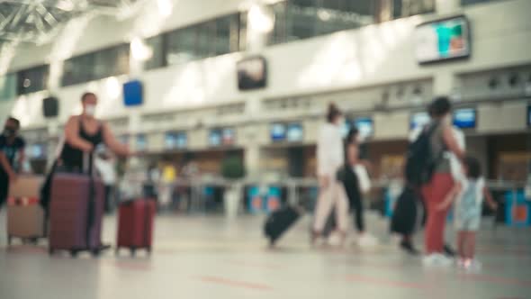 People with Suitcases Walking in an Airport Hall To Check-in Counters. alt