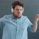 Slow Motion Portrait of Funny Guy Wearing Headphones Dancing Having Fun on Gray Color Background