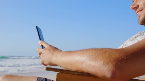 Man using mobile phone at beach in the sunshine 4k