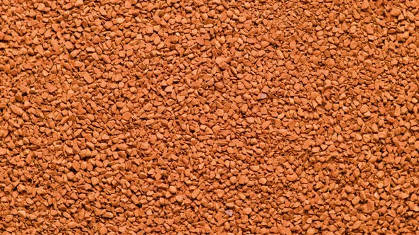 Full Frame Slowly Spinning Background of Freezedried Instant Coffee Granules Extreme Closeup View alt