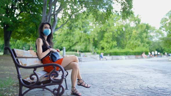 Brunette Woman Wearing Protective Face Mask in the Park. Social Distancing in the Public alt