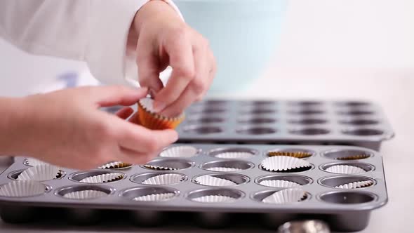 Time lapse. Lining cupcake pan with paper cupcake liners. alt