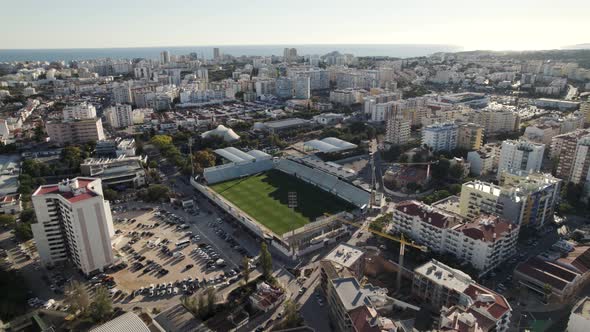 Portimao empty municipal stadium and cityscape, Portugal. Aerial circling alt