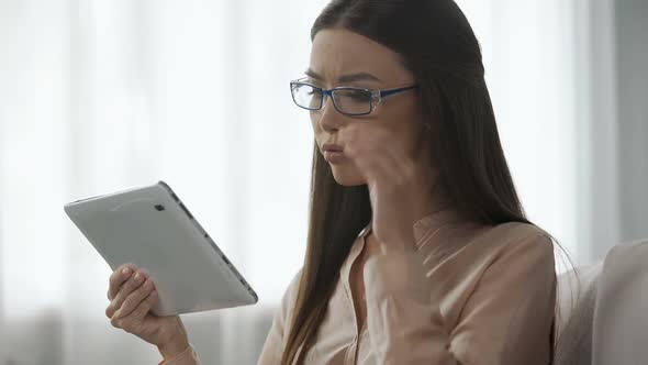 Concentrated Businesswoman Reviews Charts on Tablet, Checking Company Metrics alt