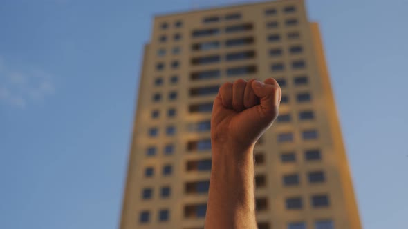 The Man Raises His Hand with a Clenched Fist Up in Protest