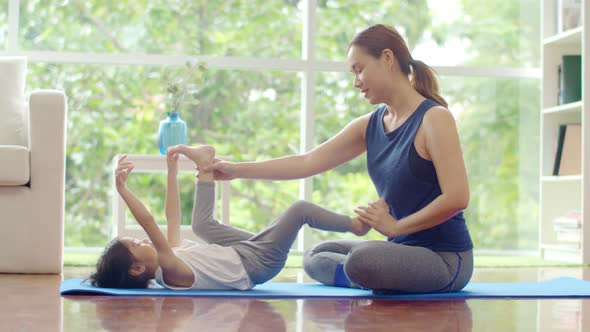 Young mother teaching her cute daughter for basic yoga
