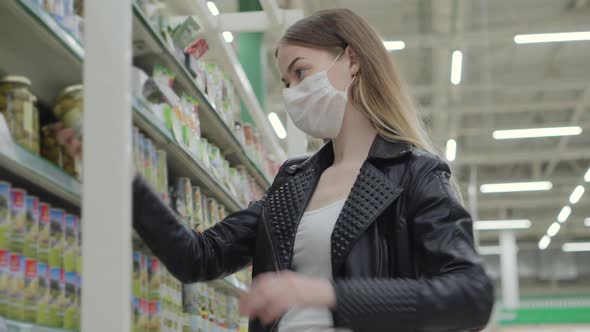 Young Lady in Medical Mask Buying Ketchup in Grocery Shop alt
