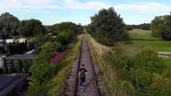 Man walking on railroad in Swedish summer alt