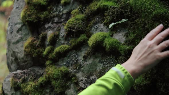 Woman meditating on a rock in the forest