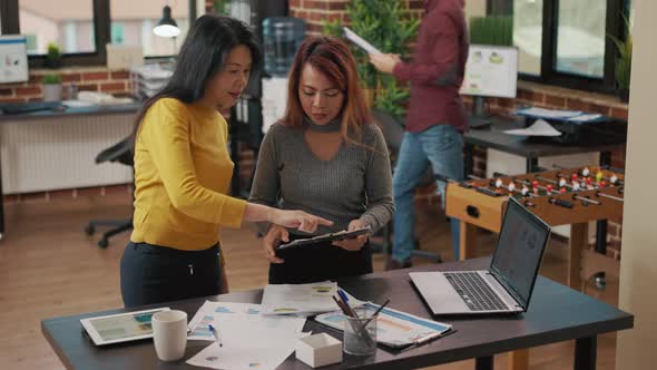 Business Partners Looking at Marketing Analysis on Laptop alt