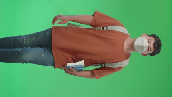 Asian Boy Student Wearing A Mask, Holding A Book And Walking On Green Screen Chroma Key alt