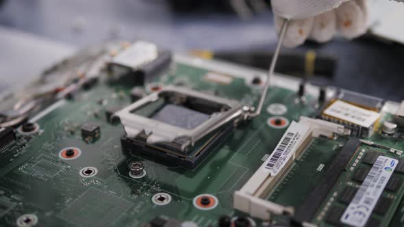 Hands of the Technician Repairing a Computer, Technician Who Changes the Computer's Processor, Close alt