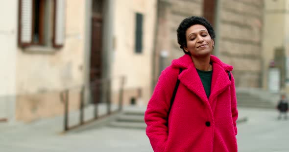 Portrait of smiling woman in red coat outdoors, Pistoia, Tuscany, Italy