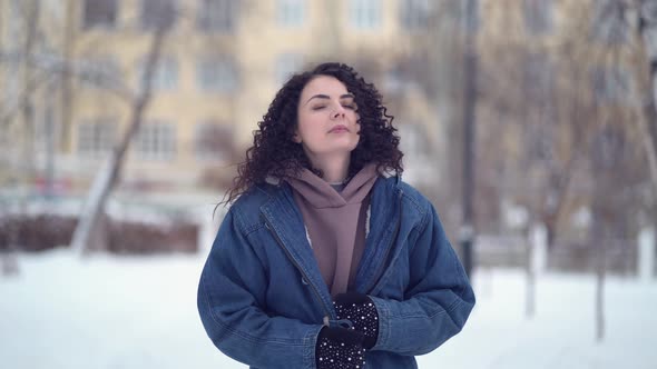 Happy Young Woman with Afro Curls in a Winter City alt