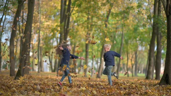 Boy and Girl Throw and Play a Fallen Leaf Slow Motion.