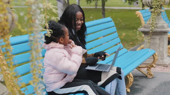 Happy African American Family Use Laptop Young Mother with Little Daughter Communicate Sitting on alt