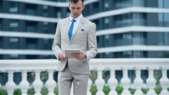 Businessman Walking With Digital Tablet