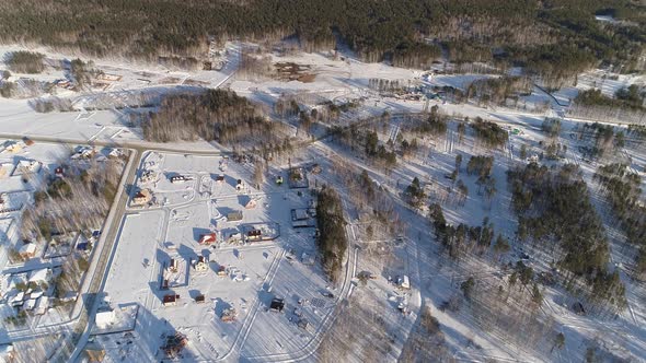 Winter cottage village with ice slide for children located among forests 04 alt