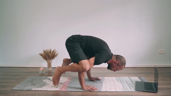 Caucasian Man Does Yoga Online A Man on a Mat Does a Pose Bakasana Yoga for Beginners Funny Yoga alt