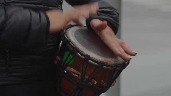 Closeup Street Musician Playing Rhythm on Drum in Town After Rain alt