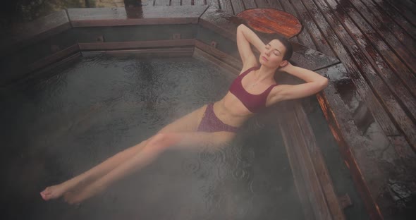 Woman in Bikini Bathing in Japanese Style Bath Outdoors alt