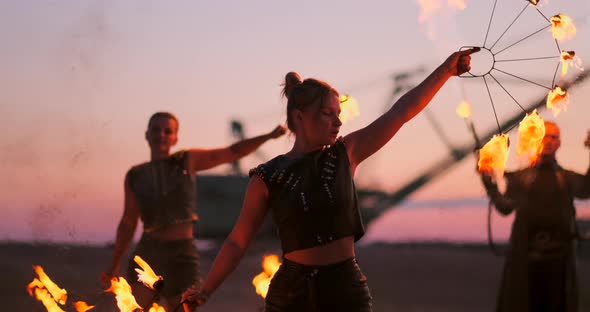 Women with Fire at Sunset on the Sand Dance and Show Tricks Against the Beautiful Sky in Slow Motion alt